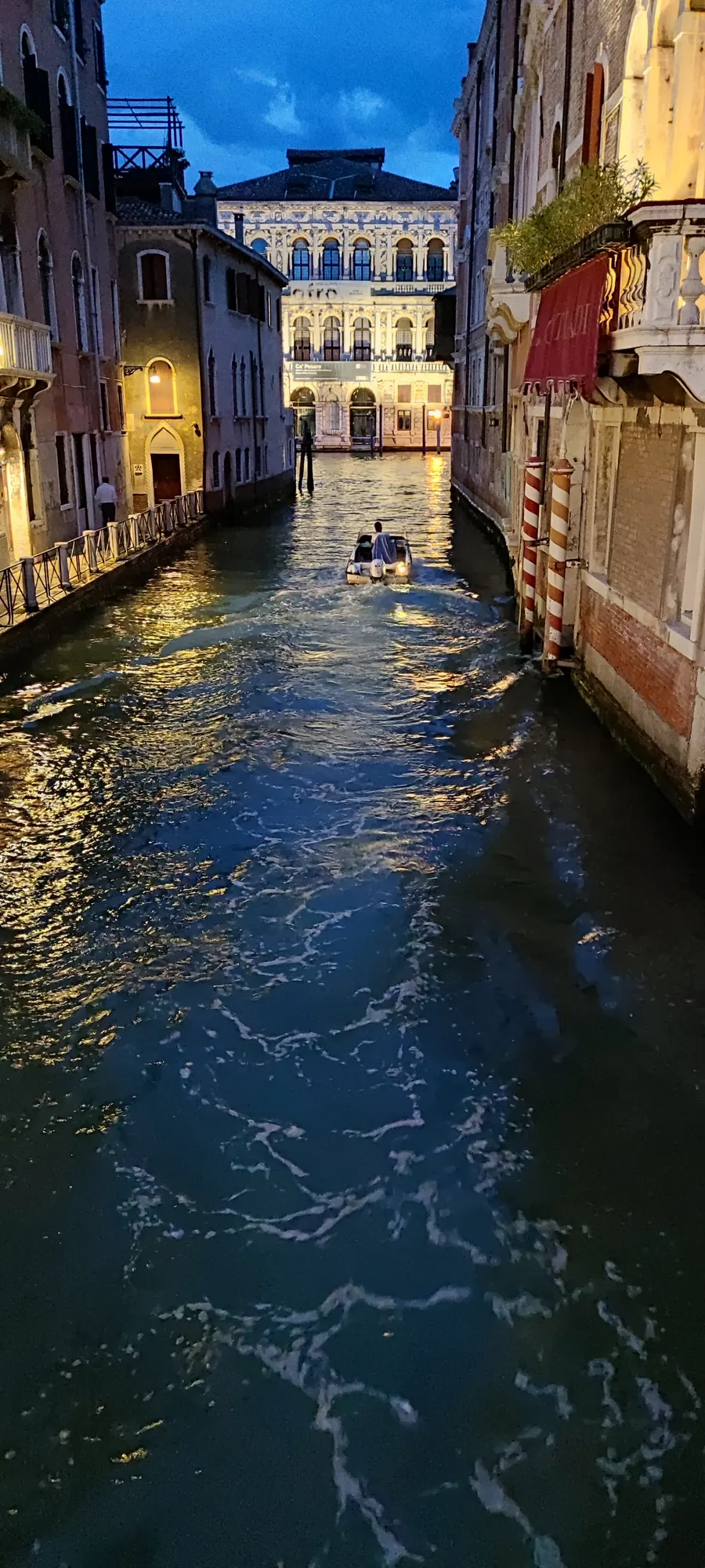 Narrow Venice canal at evening with Ca' Pesaro in the distance
